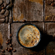 cup of coffee on brown tile table with coffee beans